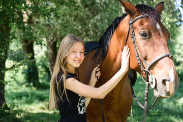 Beautiful girl gently hugs her friend - brown horse