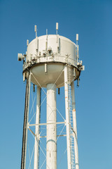 Water tower with telecommuncation devices on a blue sky
