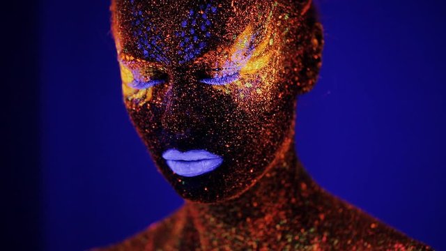 Woman face with fluorescent make up , creative makeup great for nightclubs , Halloween party, shows and music video