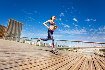 Fototapeta na wymiar Sporty young woman running in city