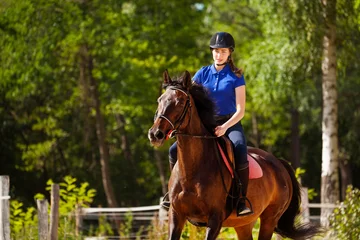 Foto op Canvas Jockey girl training horse at racetrack in summer © Sergey Novikov