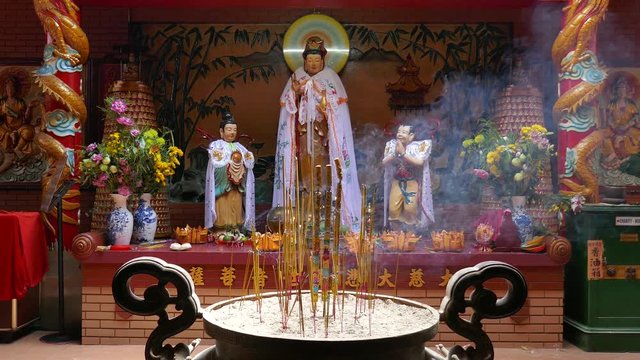 On Lang pagoda, Ho Chi Minh city, Viet Nam. Interior On Lang temple with spirit staue, incense burning and smoke. Unidentified people visit, praying for lucky and happy in first day of month