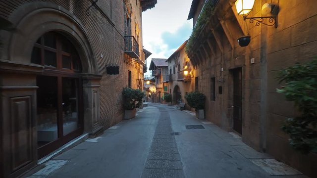 Smooth camera steady slide shot around old Spain village narrow street, with stone walls, beautiful facades with flowers, perfect for cinema digital composition or movie clips background