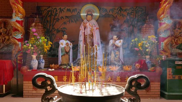 On Lang pagoda, Ho Chi Minh city, Viet Nam. Interior On Lang temple with spirit staue, incense burning and smoke. Unidentified people visit, praying for lucky and happy in first day of month