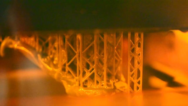 Stereolithography DPL 3d printer create detail and liquid drips, platform slowly move with liquid close-up. Progressive modern additive technology 3D printing, create scaled model by UV polymerization