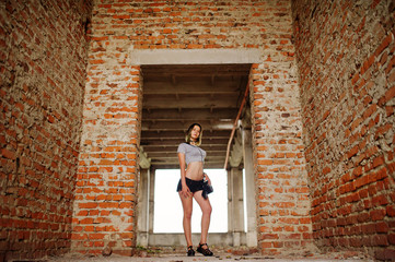 Fototapeta na wymiar Girl wear on shorts at abadoned factoty with brick walls.