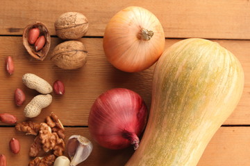 Pears, peaches, green grapes, rowan berries, walnuts, peanuts, onions, pumpkin, garlic on a wooden table after harvesting