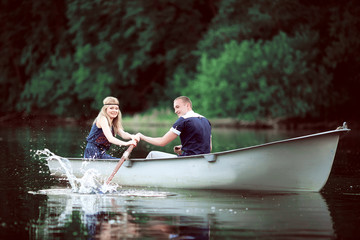 girl and guy rowing on lake