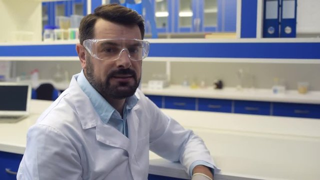 Portrait shot of serious mature chemist wearing special glasses
