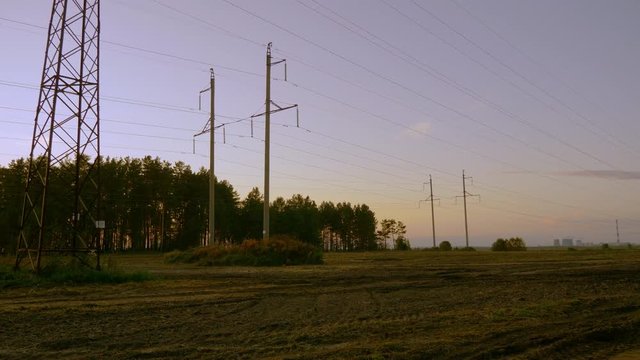 Electricity pylons and power transmission line panning. Sunset outumn evening. Outdoors handheld.