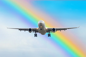 Passenger airplane arrives landing in the rainbow at the airport.