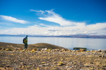 Backpacker exploring the majestic Inca Trails on Island of the Sun, Titicaca Lake, among the most scenic travel destination in Bolivia. Travel adventures and vacations in the Americas. Toned image.