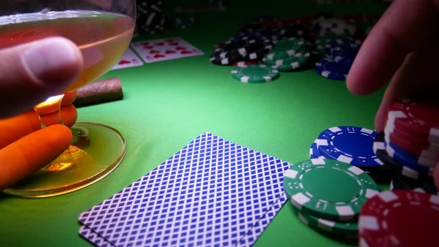 Gambling Poker Player Makes a Bet On The Green Table With Poker Chips. Cards On Table In Casino