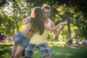 Man and woman dancing dip move training Latin American dance outdoors