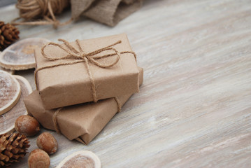 Top view on Christmas gift wrapped in craft and decorateed with various natural things. DIY present idea. Holidays concept.