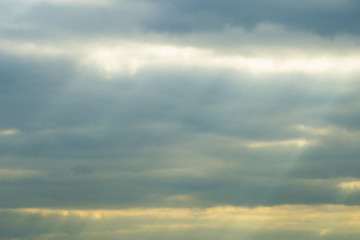 Obraz premium Promień słońca przebijający się przez ciemne chmury.