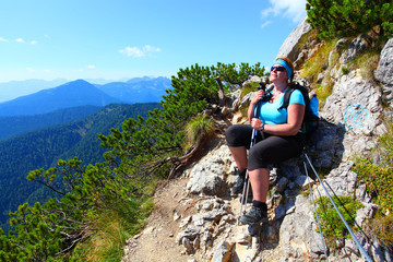 Overweight woman enjoying life. Nordic walking in alpine landscape. Healthy lifestyle and weight...
