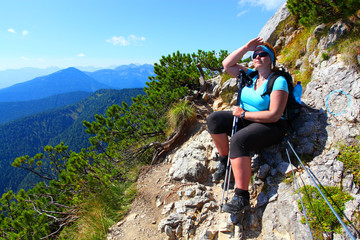 Overweight woman enjoying life. Nordic walking in alpine landscape. Healthy lifestyle and weight...