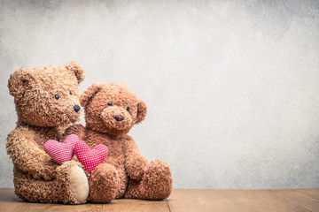 Retro Teddy Bear toys pair with handmade Valentines day love hearts front concrete wall background....