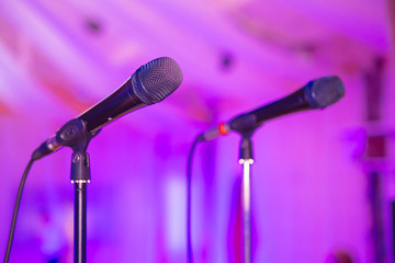 Two microphones on racks. Microphone on stage. Microphone close-up. A pub. Bar. A restaurant. Classical music. Evening. Night show. European restaurant.