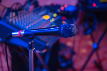 Microphone on the blurred background of the audio mixer of the musician.