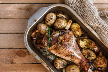 Oven baked turkey leg with potato and spices, rustic style, top view