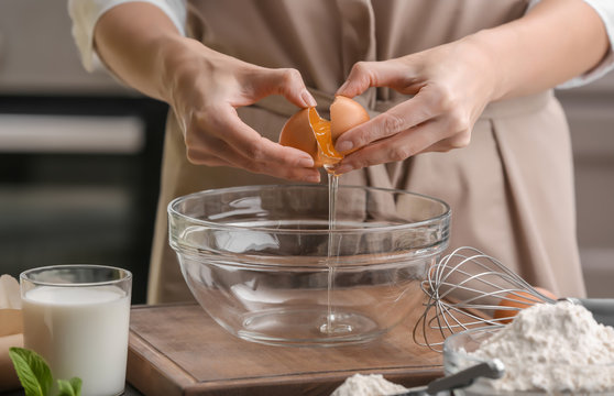 Female chef making dough in glass bowl on kitchen table
