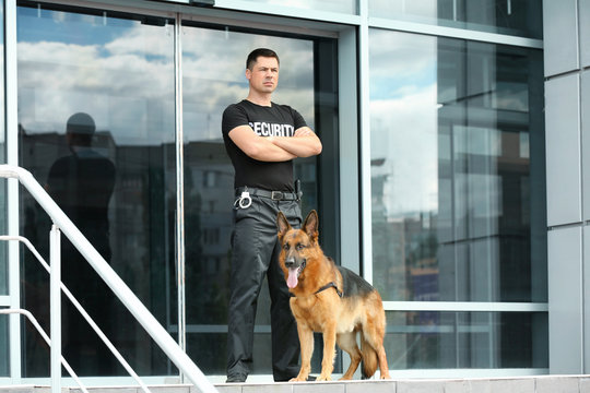 Security guard with dog near building