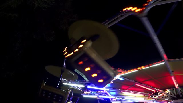 Amusement park spinning wheel ride fast rotate at night