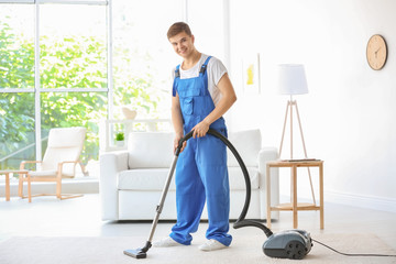 Man cleaning white carpet with vacuum in living room