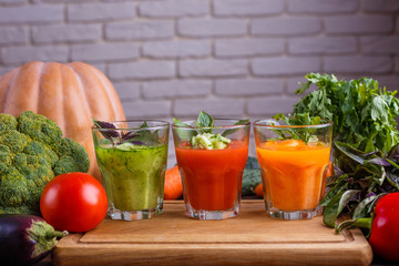 Diet concept, healthy lifestyle, low calorie detox and dietary food. Set of blended vegetable smoothies in glasses with ingredients on kitchen table, free space