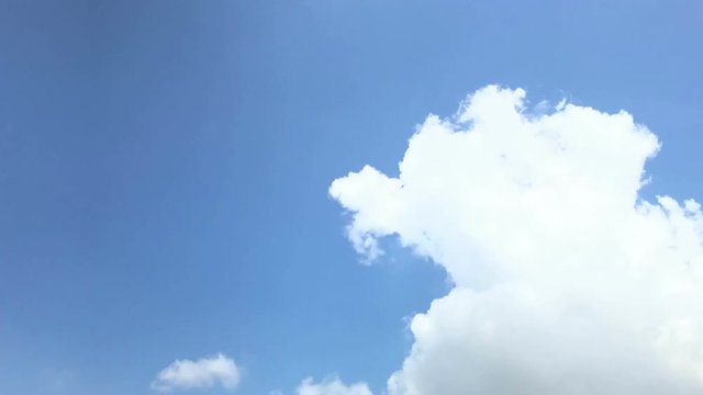 Time-lapse: white clouds flying on blue sky