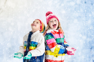 Kids playing in snow. Children play outdoors in winter snowfall.