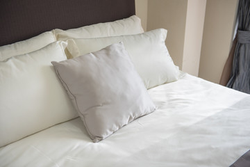 Fototapeta na wymiar set of pillows on bed in modern bedroom