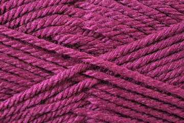 A super close up image of magenta yarn