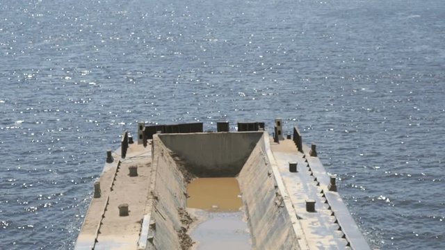 Top view of seascape - empty barge without cargo float along the river in summer sunny day