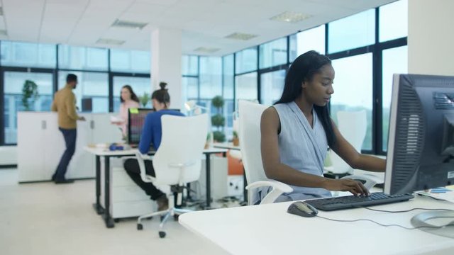  Portrait smiling businesswoman working at her desk in modern office