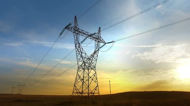 high voltage post and power lines at sunset