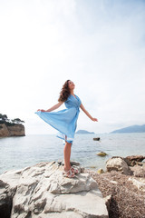 Young happy woman posing near sea, summer vacation