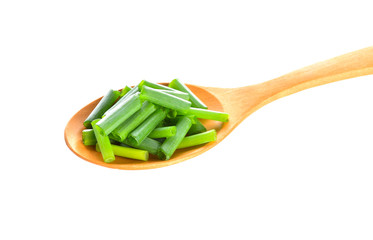 Onion leaves in wood spoon on a white background