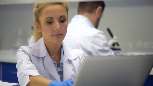 Mindful female researcher helping colleague with experiment