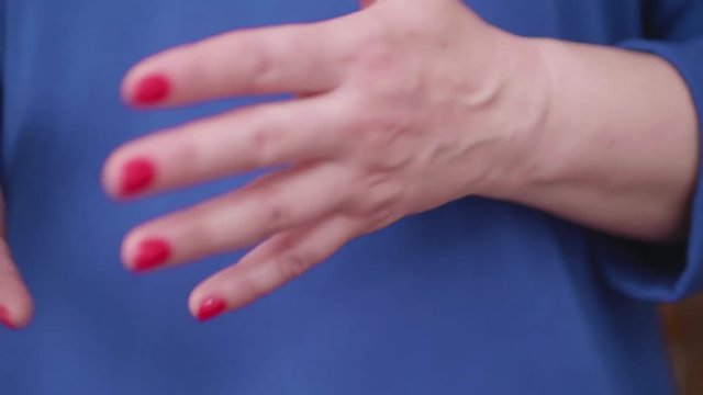 Woman's hand with red nail polish gesturing