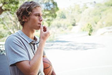 Man with basketball whistling