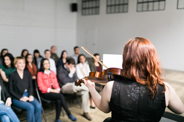 Young woman on stage playing the violin