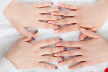 Woman presenting her beautiful painted gel hybrid nails