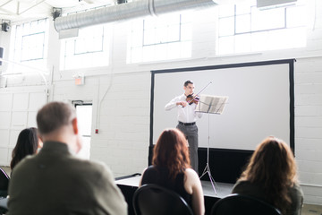 Violinist performing in an auditorium