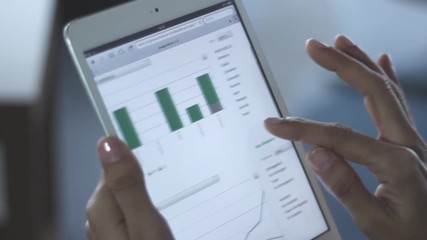 Bussineswoman using a digital tablet with stats and graphics - Powered by Adobe