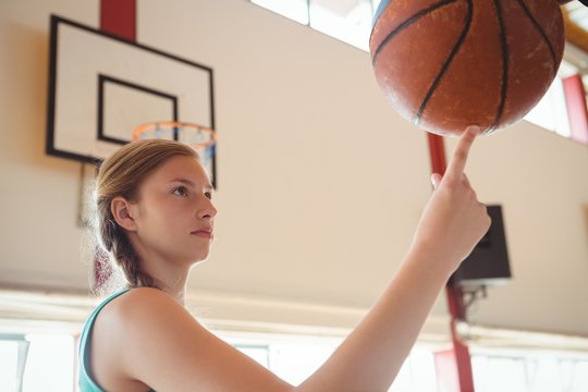 Side view of basketball player balancing ball on finger