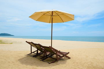 Beach chairs and umbrella on beautiful sand beach with cloudy and blue sky