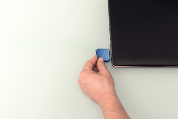 USB blue flash drive on hand with notebook computer